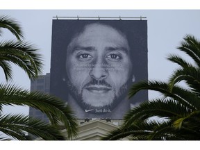 Palm trees frame a large billboard on top of a Nike store that shows former San Francisco 49ers quarterback Colin Kaepernick at Union Square, Wednesday, Sept. 5, 2018, in San Francisco. An endorsement deal between Nike and Colin Kaepernick prompted a flood of debate Tuesday as sports fans reacted to the apparel giant backing an athlete known mainly for starting a wave of protests among NFL players of police brutality, racial inequality and other social issues.