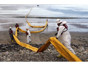 FILE - In this May 21, 2015, file photo, workers prepare an oil containment boom at Refugio State Beach, north of Goleta, Calif., two days after a ruptured pipeline created the largest coastal oil spill in California in 25 years. A California jury has found a pipeline company guilty of nine criminal charges for causing a 2015 oil spill that was the state's worst coastal spill in 25 years. The jury in Santa Barbara County reached its verdict against Plains All American Pipeline of Houston on Friday, Sept. 7, 2018, following a four-month trial.