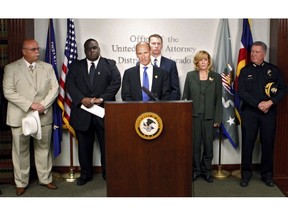 FILE - In this May 31, 2012, file photo, then Assistant U.S. Attorney Bob Troyer, backed by representatives of law enforcement agencies, speaks at a news conference in Denver. In an op-ed published in The Denver Post late Friday, Sept. 28, 2018, U.S. Attorney Troyer, Colorado's top federal prosecutor, says his office may take legal action against licensed marijuana business that violate state law or use their status under state law "as a shield" but sell to the black market.