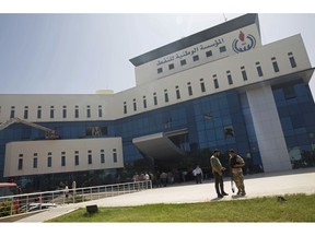 Security forces gather at the headquarters of the national oil company after an attack by gunmen in Tripoli, Libya, Monday, Sept. 10, 2018. Officials say security forces of Libya's U.N.-backed government stormed the building in the capital Tripoli after gunmen had earlier gone in, taking hostages and starting a fire. They say at least one explosion rocked the building soon after the gunmen stormed it, starting the blaze that swiftly spread through the lower floors.