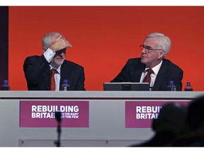 Britian's Labour leader Jeremy Corbyn, left, and Shadow Chancellor of the Exchequer John McDonnell look on during the Labour Party's annual conference at the Arena and Convention Centre (ACC), in Liverpool, England, Monday, Sept. 24, 2018. Britain's main opposition party took a step at its annual conference toward backing a new referendum on Brexit -- but stopped short of saying the vote should include an option not to leave the European Union at all.