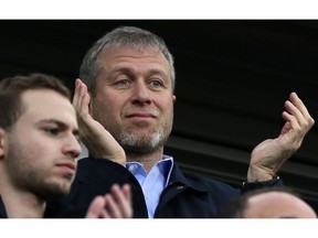 FILE - In this Saturday, March 22, 2014 file photo, Chelsea's Russian owner Roman Abramovich applauds his players after they defeated Arsenal 6-0, in the English Premier League soccer match between Chelsea and Arsenal at Stamford Bridge stadium in London. Roman Abramovich withdrew an application for residency in Switzerland, according to the Swiss migration office, as lawyers for the Russian oligarch lashed out at "defamatory" allegations involving money laundering and denied that he has links to organized crime.