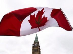 A Canadian flag with a marijuana leaf on it flies during a 4/20 rally on Parliament Hill in Ottawa. Legalization on Oct. 17 will boost the economy, TD says.
