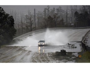 A car drives through water caused by the rain from Florence, now a tropical storm on U.S. 74/76 in Leland, N.C., Saturday, Sept.15, 2018. The rain from Hurricane Florence was expected to continue through Sunday.