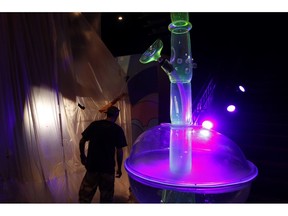 In this Tuesday, Sept. 18, 2018 photo, a man walks by a 24-foot-tall bong at the Cannabition cannabis museum in Las Vegas. The museum celebrating all things cannabis with displays that include a glass bong taller than a giraffe and huggable faux marijuana buds is the newest tourist attraction in Las Vegas.