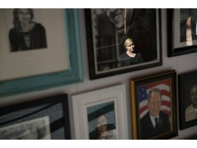 In this Sept. 25, 2018, photo, a woman looks at painted portraits of victims of the Oct. 1, 2017, mass shooting in Las Vegas on display at the Clark County Government Center in Las Vegas.