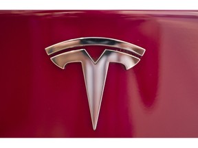 FILE - This Aug. 8, 2018 file photo shows the Tesla emblem on the back end of a Model S in the Tesla showroom in Santa Monica, Calif. Tesla investors have taken a wild ride as Wall Street values the promise of one of the world's leading electric car makers, the hurdles the company faces as it tries to become a world-class manufacturer, and a mercurial CEO who can get the market buzzing with a single tweet.