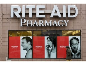 FILE - In this Feb. 10, 2017, file photo, a man walks by a Rite Aid pharmacy in the Oakland section of Pittsburgh. After two failed buyouts, Rite Aid will shuffle its board of directors and spread out leadership at the top of the drugstore chain. Rite Aid said Thursday, Sept. 27, 2018, that three new, independent directors will be nominated to its board, and CEO John Standley will no longer hold the title of chairman. That will go to current board member Bruce Bodaken.
