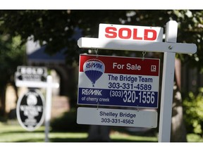 FILE- In this Aug. 30, 2018, file photo sold placards top sale signs outside homes on the market in Denver. On Tuesday, Sept. 25, the Standard & Poor's/Case-Shiller 20-city home price index for July is released.