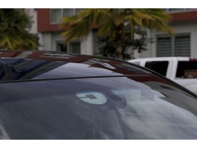 FILE- In this June 6, 2018, file photo Uber driver Joshua Oh drives in Honolulu. Uber has created a feature on its app to reach out to passengers and drivers if it detects an accident or unplanned stop. Drivers will also have access to a hands-free feature to pick up passengers without touching their phones, and they will no longer see data detailing where they retrieved passengers in the past.