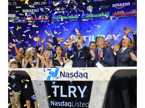 FILE- In this July 19, 2018, file photo Brendan Kennedy, third from right in front, CEO and founder of British Columbia-based Tilray Inc., a major Canadian marijuana grower, leads cheers as confetti falls to celebrate his company's IPO (TLRY) at Nasdaq in New York. Investors are craving marijuana stocks as Canada prepares to legalize pot next month, leading to giant gains for Canada-based companies listed on U.S. exchanges.