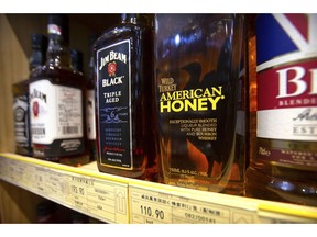 FILE - In this  July 7, 2018, file photo, whiskeys distilled and bottled in the U.S. are displayed for sale in a grocery store in Beijing. Kentucky's bourbon distilleries turned up the pace of production again last year, boosting overall inventory to 7.5 million barrels of aging whiskey, the highest volume since 1972.