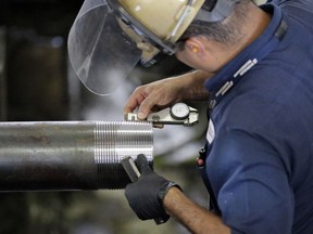 FILE- In this June 5, 2018, file photo Erik Cordova inspects a steel pipe at the Borusan Mannesmann Pipe manufacturing facility Tuesday, June 5, 2018, in Baytown, Texas. On Friday, Sept. 14, the Federal Reserve reports on U.S. industrial production for August.