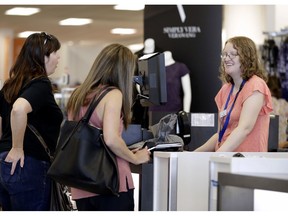 FILE- In this Aug. 28, 2018, file photo cashier Liz Moore, right, checks out customers Christie Meeks, center, and Lisa Starnes, left, at a Kohl's store in Concord, N.C. On Friday, Sept. 28, the Commerce Department issues its August report on consumer spending, which accounts for roughly 70 percent of U.S. economic activity.