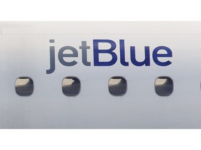 FILE - In this Jan. 20, 2011, file photo, a JetBlue logo is displayed on the side of a jet as it taxis at Boston's Logan International Airport. JetBlue is following the lead of larger rivals by offering a stripped-down ticket with fewer options than regular economy fares. The airline says customers who take the cheapest fare might have to accept limits on when they board, their seat, and whether they can change or cancel a reservation. JetBlue Airways Corp. President Joanna Geraghty said in a note to employees Friday, Sept. 28, 2018, that the new fare class will take effect sometime next year.