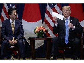 President Donald Trump takes a letter from North Korean leader Kim Jong-un from his suit coat pocket during a meeting with Japanese Prime Minister Shinzo Abe at the Lotte New York Palace hotel during the United Nations General Assembly, Wednesday, Sept. 26, 2018, in New York.