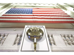 FILE- In this May 17, 2018, file photo an American flag hangs above the bell podium on the floor of the New York Stock Exchange. The U.S. stock market opens at 9:30 a.m. EDT on Thursday, Sept. 27
