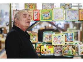 In this Friday, Sept. 21, 2018 photo, owner J. Louis Karp stands beside a case of vintage lunchboxes at Main Auction Galleries Inc., in downtown Cincinnati. Karp, a longtime auctioneer of Cincinnati-area estates has come upon a Baby Boomer delight: hundreds of vintage lunchboxes featuring the heroes of their childhood's comic books, TV shows, cartoon strips, movies and more.