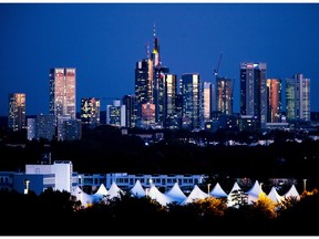 The buildings of the banking district are illuminated by red clouds after sunset in Frankfurt, Germany, Tuesday, Sept. 25, 2018.