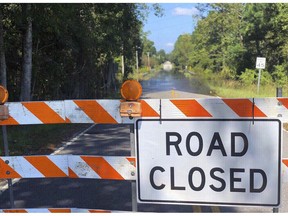 A sign stands near the Carter's Crossroads community in Georgetown County, a road adjacent to Boser Swamp is flooded over, Wednesday, Sept. 26, 2018, in Georgetown County, S.C. This is one of many lowlying areas in this and other nearby farming communities where roads are blocked off days after the rains of Florence have stopped.