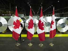 Canadian flags in front of rolls of coated steel at Stelco in Hamilton.