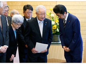 FILE - In this March 30, 2018, file photo, Japanese Prime Minister Shinzo Abe, right, meets with Shigeo Iizuka, second from right, leader of a group of families of Japanese abducted by North Korea, and Sakie Yokota, second from left, mother of Megumi Yokota, one of the Japanese abductees and other members at Abe's official residence in Tokyo. Abe is expected to be re-elected by his ruling Liberal Democratic Party to a third term as its leader on Thursday, Sept. 20, 2018, paving the way for him to serve as prime minister for up to three more years.