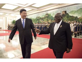 China's President Xi Jinping, left, and Ghana's President Nana Akufo-Addo, right, review the honor guard of Chinese People's Liberation Army during the welcome ceremony at the Great Hall of the People Saturday, Sept. 1, 2018.