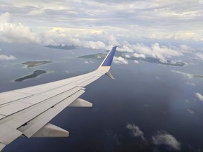 This Oct. 28, 2017, photo shows the right wing and winglet of a United Airlines 737-800ER airplane descending through a layer of clouds over the Chuuk Lagoon en route to Chuuk Airport in Weno, Federated States of Micronesia. An Air Niugini plane hit the water short of the runway Friday morning, Sept. 28, 2018 while trying to land at Chuuk Island in the Federated States of Micronesia.