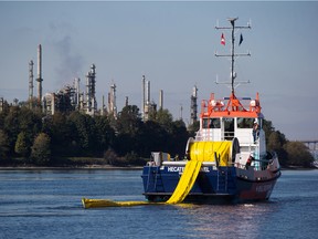 A spill response boat deploys a boom in front of the Parkland Fuel Corp. Burnaby Refinery during an emergency response exercise in Burrard Inlet near the Kinder Morgan Inc. Westridge Marine Terminal in Burnaby, British Columbia, Canada, on Wednesday, Sept. 19, 2018.