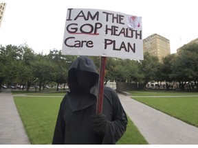 Cary Clark, dressed as the Grim Reaper, protest during a rally at Burnett Park in Fort Worth, Texas, Wednesday, Sept. 5, 2018. Democratic nominee for Texas Attorney General Justin Nelson hosted the Fort Worth Rally for Preexisting Coverage Protection.