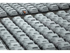 In this photo taken on Tuesday, Sept. 4, 2018, a worker rides a bicycle among parked cars at the Port of Zeebrugge, Belgium. Brace for Brexit bedlam if EU-UK divorce talks fail and on that dreaded March 30, 2019, the curtain of custom duties is raised across the Channel.