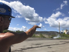 Brian Weekly, a contractor at West Virginia's Grant Town coal-fired power plant, gestures toward the small facility's smokestack, Thursday, Aug. 23, 2018 in Grant Town, W.Va. Weekly says opponents of the coal industry are behind warnings of health risks from smokestack emissions under the Trump administration's plan. President Donald Trump picked West Virginia where he announced rolling back pollution rules for coal-fired power plants. But he didn't mention that the northern two-thirds of West Virginia, with the neighboring part of Pennsylvania, would be hit hardest.