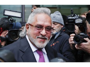 F1 Force India team boss Vijay Mallya smiles as he arrives to attend a hearing at Westminster Magistrates Court in London, Wednesday, Sept. 12, 2018. Investigators have accused the 62-year-old of paying $200,000 to a British firm for displaying his company Kingfisher's logo during the Formula One World Championships in London and some European countries in the 1990s.