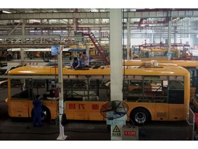 In this Wednesday, Aug. 22, 2018, photo, workers assemble electric buses at a factory in Liaocheng city in east China's Shandong province. China announced more tariff cuts Wednesday, Sept. 26 on construction machinery and other goods but no action on U.S. complaints about its technology policy that are fuelling an escalating trade battle. (Chinatopix Via AP)