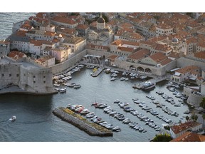 This Sept. 4, 2018 photo shows the harbor in the old town of Dubrovnik from a hill above the city. Crowds of tourist are clogging the entrances into the ancient walled city, a UNESCO World Heritage Site, as huge cruise ships unload thousands more daily.