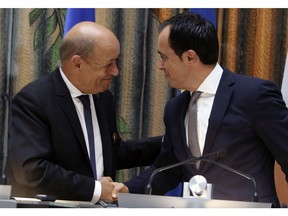 Cyprus Foreign Minister Nikos Christodoulides, right, and his French counterpart Jean-Yves Le Drian shake hands after they make statements to media during a press conference after their meeting at the Cypriot foreign ministry in capital Nicosia, Friday, Sept. 7, 2018. Cyprus and France have in recent years bolstered ties in the fields of energy, the economy, defense, and culture. French oil and gas company Total is licensed to search for hydrocarbons off Cyprus' southern coast.
