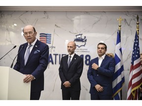 Greece's Prime Minister Alexis Tsipras, right, and Simos Anastasopoulos, President of the American-Hellenic Chamber of Commerce, center, listen to U.S. Commerce Secretary Wilbur Ross, during a visit at Thessaloniki International Trade Fair, at the northern Greek city of Thessaloniki, Saturday, Sept. 8, 2018. Thousands of police officers will be on duty in the northern city Saturday, as anti-austerity protests are planned throughout the city, at the same time when Tsipras plans to outline his economic platform for a country emerging from a decade of international bailout measures.