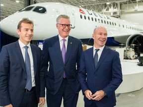 Delta Air Lines CEO Ed Bastian, centre, talks with Airbus President of commercial aircraft Guillaume Faury, left, and Bombardier President and CEO Alain Bellemare following a ceremony to mark the first delivery of Airbus' Delta Airlines A220 at a Bombardier assembly plant in Mirabel, Que., Friday, October 26, 2018.