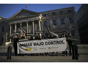 Activists holding banners in the shape of missiles and a banner reading in Spanish "Arms under control" protest against the sale of weapons to Saudi Arabia in front of the Spanish Parliament in Madrid, Wednesday, Oct. 24, 2018. Spain's prime minister says his government will fulfill past arms sales contracts with Saudi Arabia despite his "dismay" over the "terrible murder" of journalist Jamal Khashoggi.