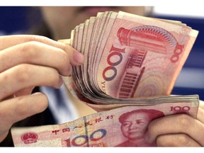 In this photo taken on Aug. 25, 2010, a bank clerk counts Chinese 100 Yuan notes in Shanghai. China's politically sensitive yuan has sunk to a 22-month low against the dollar after the U.S. Treasury declined to label Beijing a currency manipulator amid a mounting tariff battle.