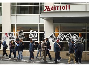 FILE - In this Oct. 4, 2018 file photo, hotel workers strike in front of a Marriott hotel in San Francisco. New technology threatening to make some hotel jobs obsolete is among the concerns prompting thousands of Marriott workers to walk off their jobs across the U.S. in recent weeks.