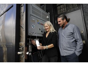 The Skysource/Skywater Alliance co-founders David Hertz, right, and his wife Laura Doss-Hertz demonstrate how the Skywater 300 works Wednesday, Oct. 24, 2018, in Los Angeles. The company received the $1.5 million XPrize For Water Abundance for developing the Skywater 300, a machine that makes water from air.