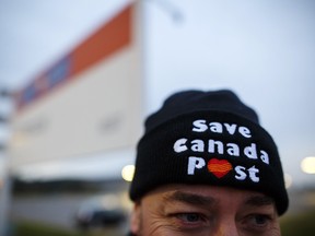 A worker wears a "Save Canada Post" hat during a Canadian Union of Postal Workers (CUPW) strike in front of the Gateway Postal facility in Toronto, Ontario, Canada, on Tuesday, Oct. 23, 2018.