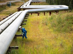 A man works next to pipelines at Cenovus Energy's Foster Creek plant.