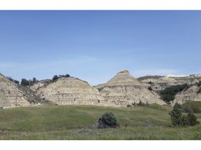FILE - This Aug. 1, 2018, file photo, shows a view of the badlands landscape at Theodore Roosevelt National Park near Medora, N.D. North Dakota regulators won't order a company to stop work on an oil refinery near Theodore Roosevelt National Park so they can study the appropriateness of the site. The decision eliminates a potential big roadblock for the $800 million Davis Refinery. But it's based on a technicality in state law and is unlikely to end debate over whether the refinery is too close to the state's top tourist attraction.