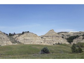 FILE - This Aug. 1, 2018, file photo, shows a view of the badlands landscape at Theodore Roosevelt National Park near Medora, N.D. Environmental groups opposing the site of an oil refinery being developed near Theodore Roosevelt National Park in North Dakota want a judge to reconsider his recent recommendation that state regulators dismiss the groups' challenge. They accuse the Davis Refinery developer of not updating state officials about revisions to the project. Meridian Energy Group says it had no reason or requirement to do so.