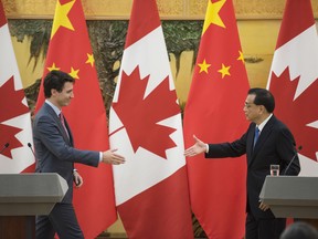 Canadian Prime Minister Justin Trudeau, left, greets Chinese Premier Li Keqiang at the end of a press conference at the Great Hall of the People in Beijing Monday, Dec. 4, 2017.