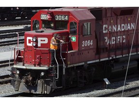 A Canadian Pacific Railway employee walks along the side of a locomotive in a marshalling yard in Calgary, Wednesday, May 16, 2012. Canadian Pacific Railway Ltd. is raising its full-year financial guidance following what it called a record-setting third quarter and a strong outlook for the remainder of the year.