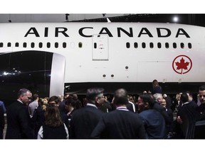 People view the newly revealed Air Canada Boeing 787-8 Dreamliner aircraft at a hangar at the Toronto Pearson International Airport in Mississauga, Ont., Thursday, February 9, 2017. Air Canada saw its third-quarter profit drop compared with a year ago amid rising fuel prices as operating revenue climbed 11 per cent.