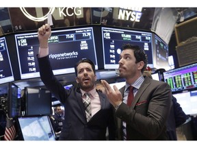 Jonathan Scott, left, and Drew Scott, of HGTV's "Property Brothers" cable television show, mimic traders as they visit the  New York Stock Exchange in 2014. Cineflix, the company that makes "Property Brothers" and other TV programs, is being sued in Ontario for wages and overtime.